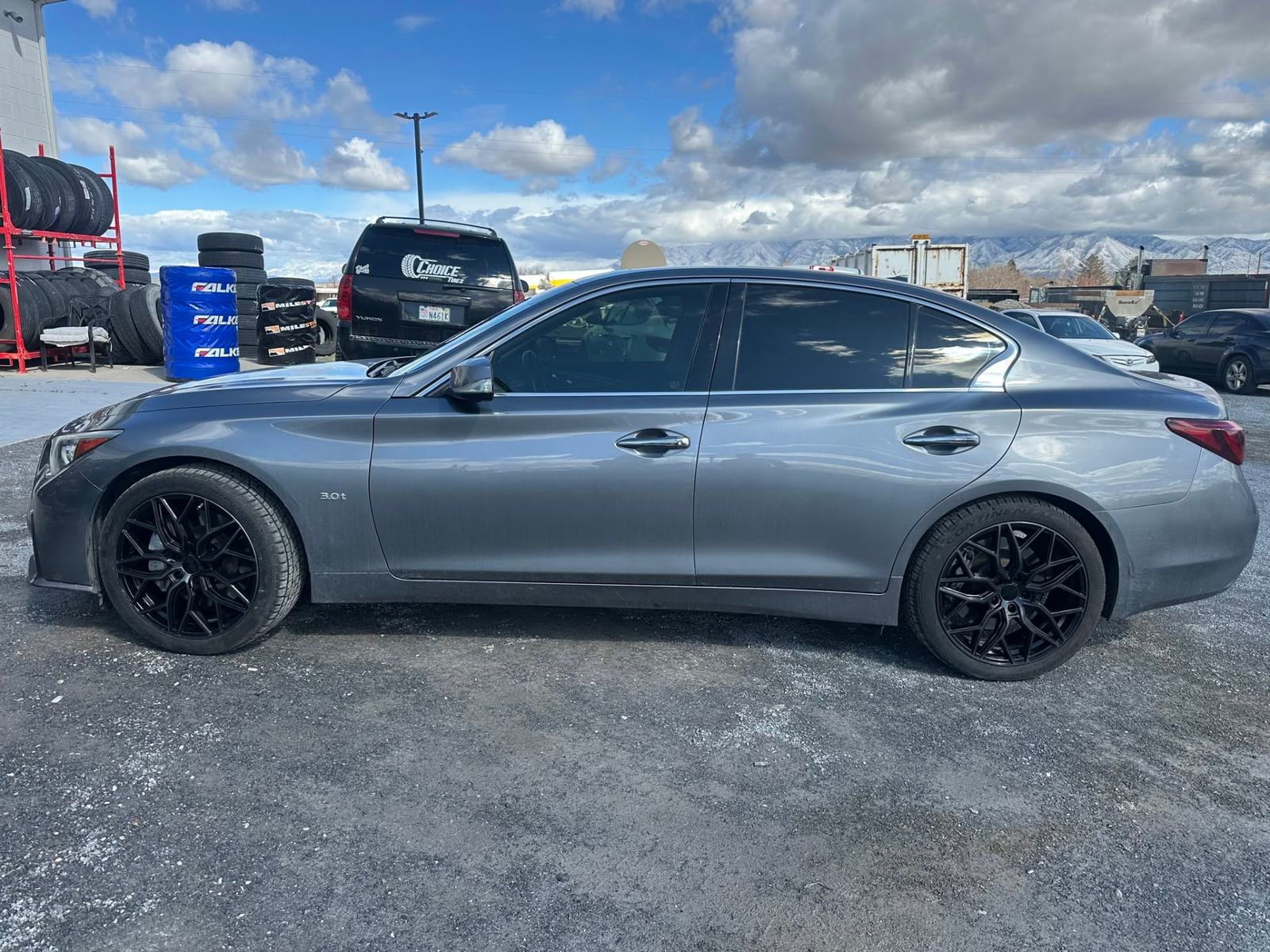 A sedan on new black alloy wheels parked at the Choice Tires lot in Grantsville, Utah