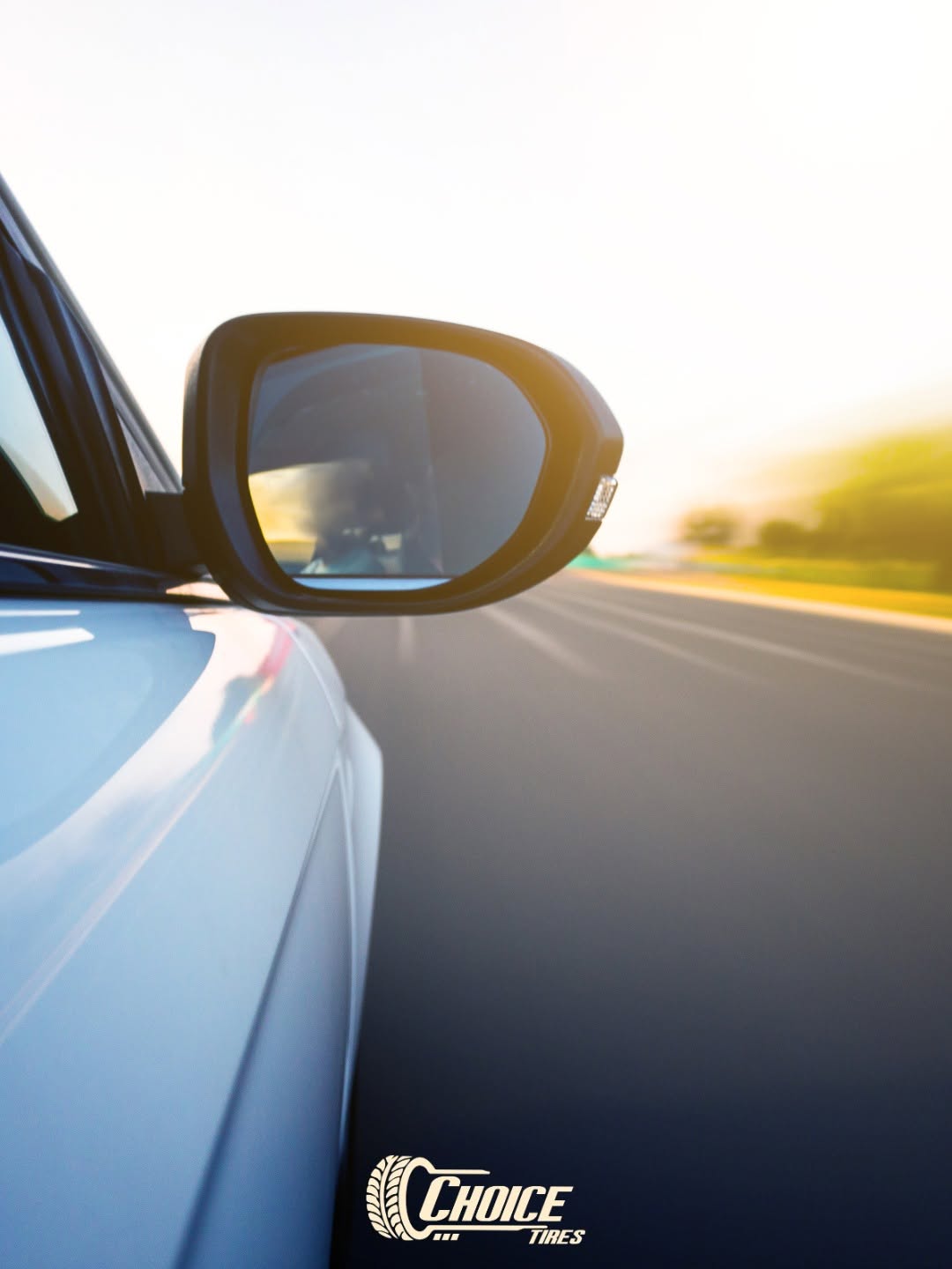View along a highway at sunrise from the side mirror of a car on Choice Tires rubber